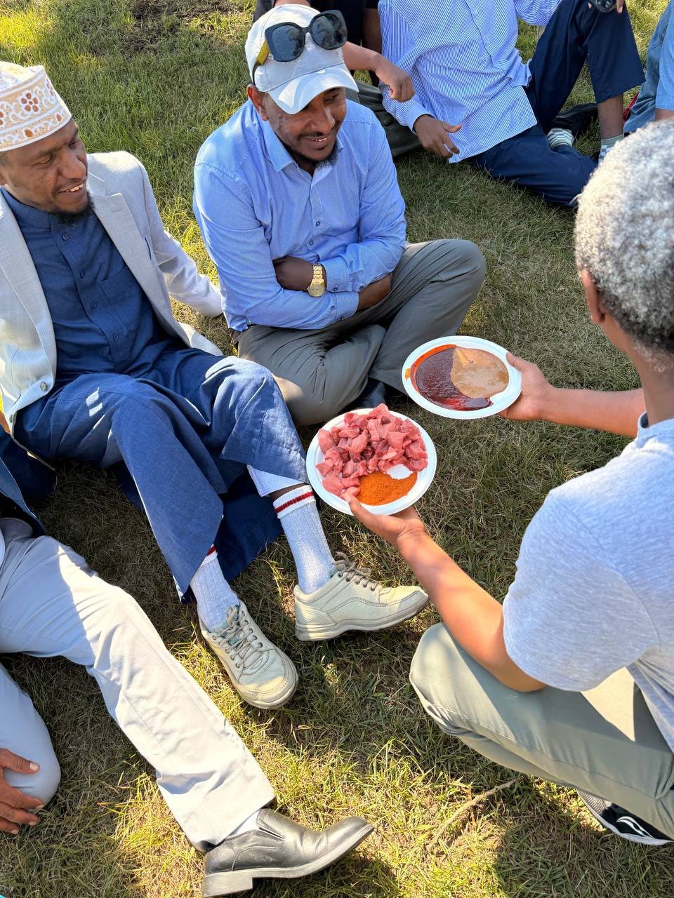 Community members sharing a meal outdoors at a park gathering